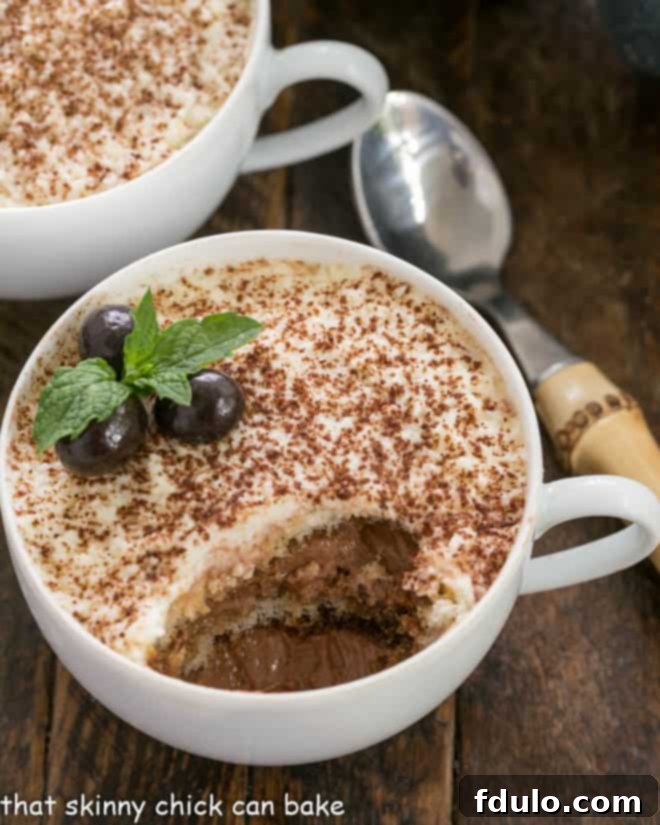 Chocolate Tiramisu Dessert with layers of chocolate mousse and espresso dipped ladyfingers An individual cup of chocolate tiramisu with a spoon removing a portion, showcasing the exquisite layers of mousse and espresso-dipped ladyfingers.