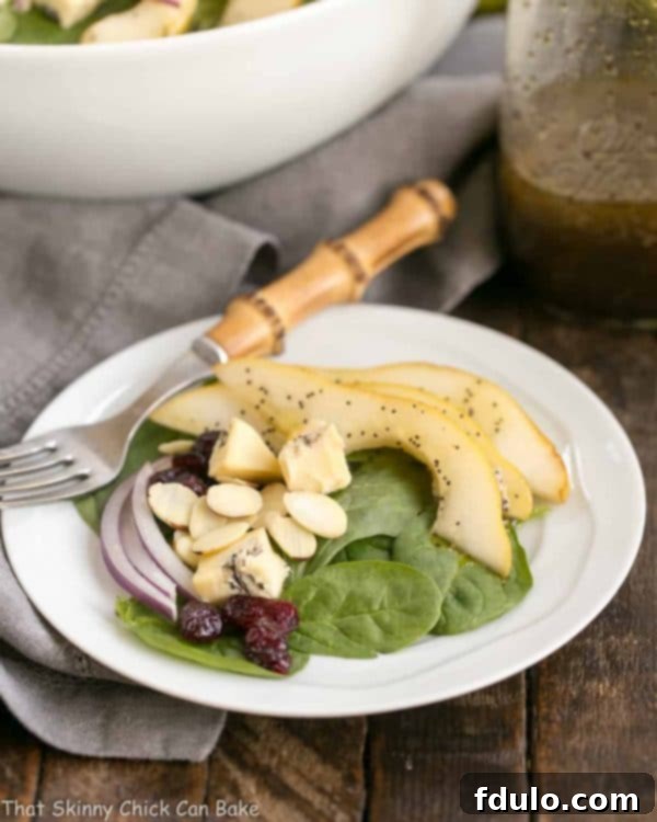 Jeweled Pear and Blue Cheese Spinach Salad 2 A vibrant Spinach Pear Salad with Cranberries and Blue Cheese, perfectly dressed with Poppy Seed Dressing, set for a delightful autumn or winter meal.