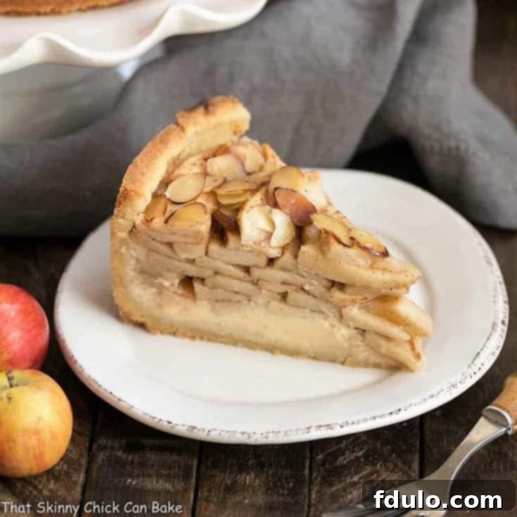 Cream Cheese Apple Torte on a round white dessert plate, beautifully sliced and ready to serve.