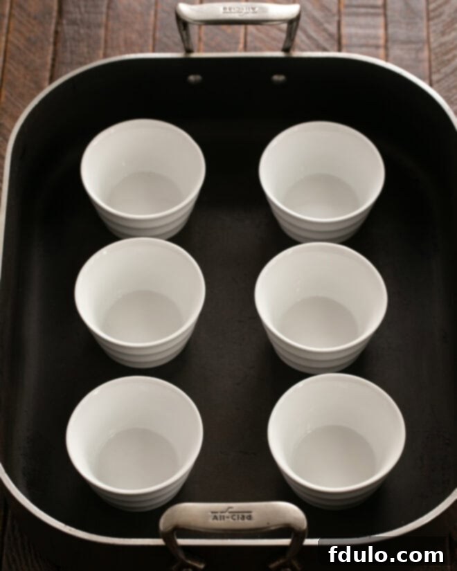 Ramekins placed in a large rimmed baking dish before baking.