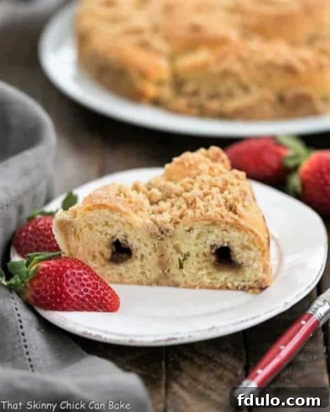 Slice of Streusel Coffee Cake Recipe on a white plate with strawberries