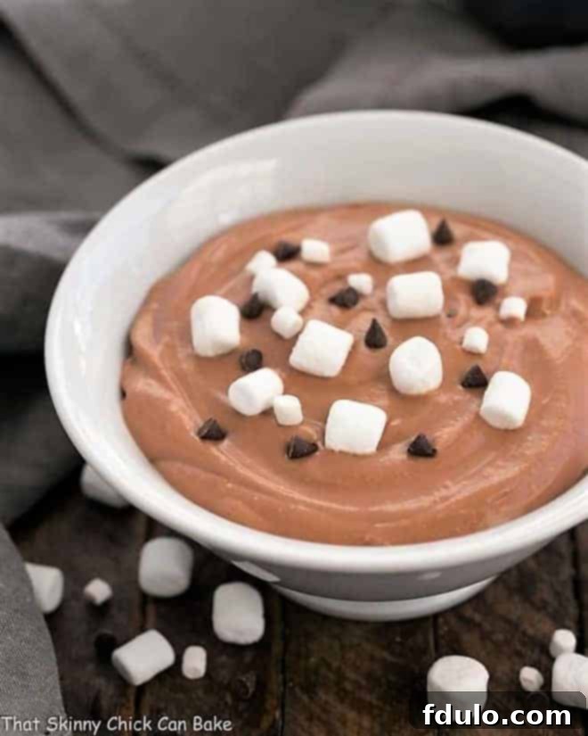 Easy S'mores Dessert Dip in a white ceramic bowl topped with marshmallows and chocolate chips.