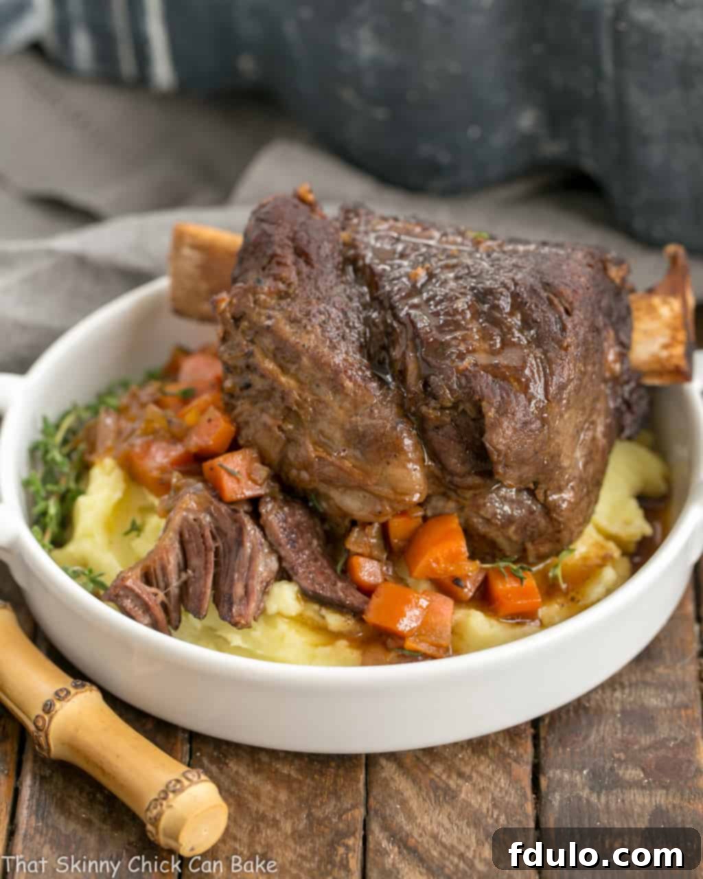 A beautifully presented plate of Instant Pot Beef Short Ribs, tender and succulent, served over a bed of creamy mashed potatoes and vibrant steamed carrots.