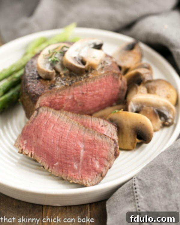 Bistrot Paul Bert's Legendary Pepper Steak 2 Mushroom Topped Pepper Steak fanned out on a white plate, ready to be served.