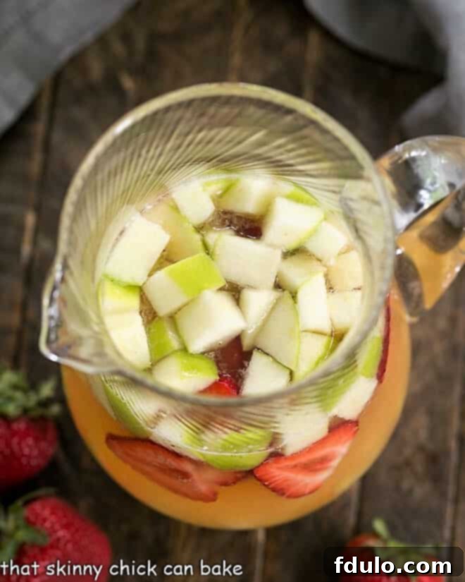 An inviting overhead view of a pitcher of White Wine Sangria with Rum, showcasing the colorful fruit medley.