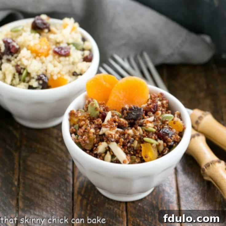 2 small white ceramic bowls filled with quinoa salad next to 2 bamboo forks