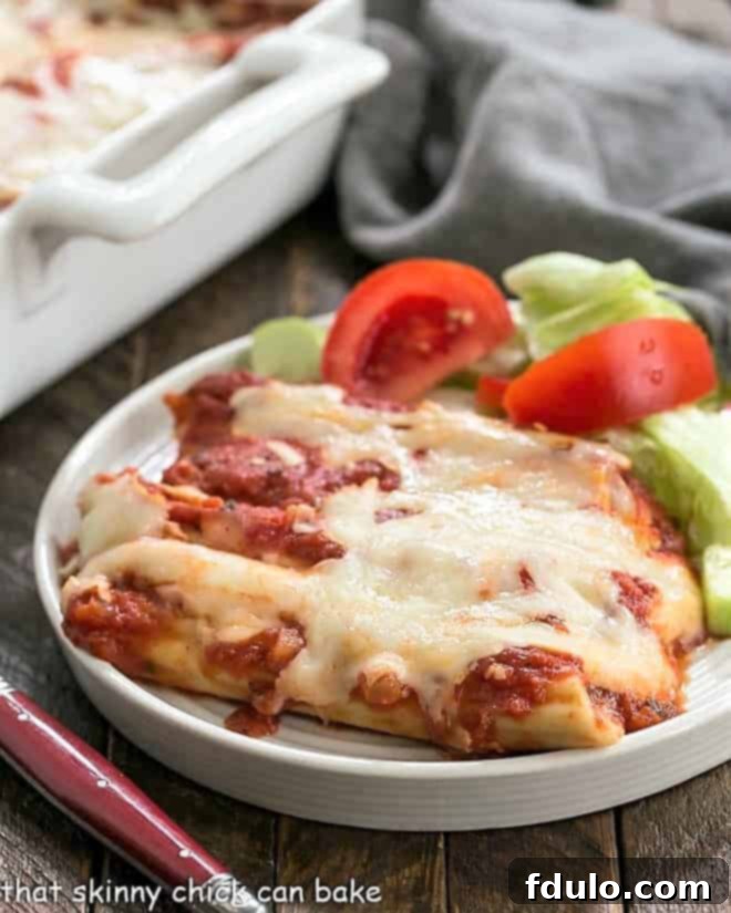 Cheese Manicotti on a white plate with a lettuce salad.