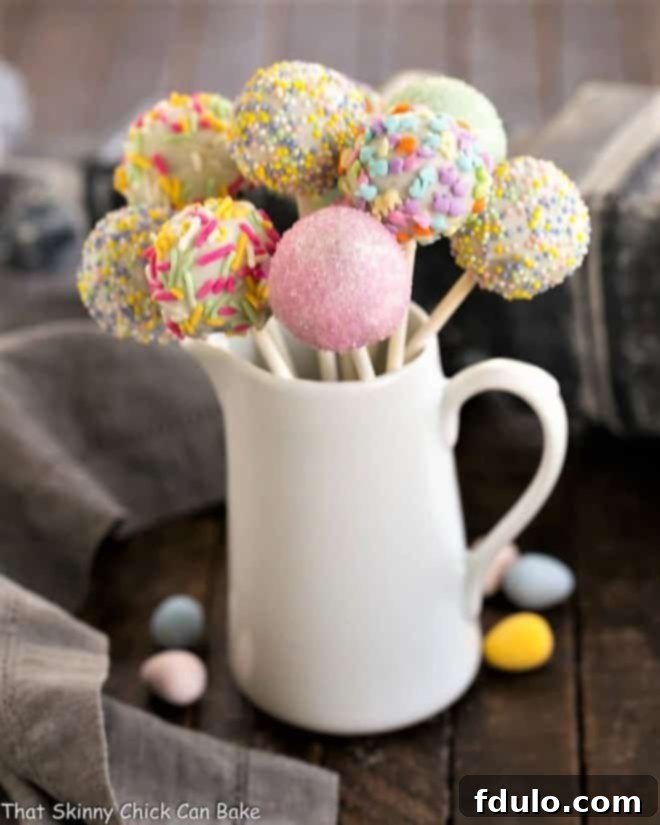 Vibrant Easter Cake Pops elegantly displayed in a ceramic pitcher, ready for a spring celebration.