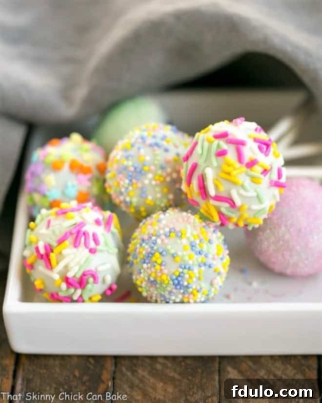 Beautifully decorated Easter Cake Pops resting on a square plate, showcasing their festive sprinkles.