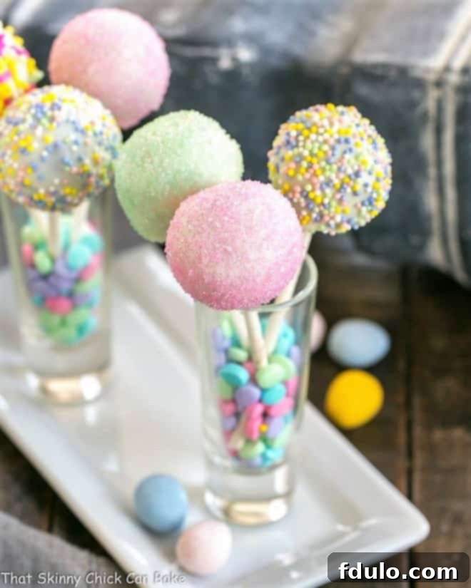 A festive arrangement of Easter Cake Pops, presented in shot glasses on an elegant porcelain tray.