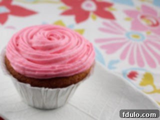 Classic Vanilla Buttercream Cupcakes 2 Close-up of vanilla cupcakes, two frosted with white buttercream and sprinkles, ready for a cause.