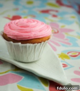 Classic Vanilla Buttercream Cupcakes 3 Three vanilla cupcakes frosted with buttercream and colorful sprinkles, arranged aesthetically.