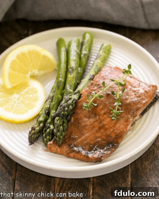 Salmon, asparagus and lemon slices on a white plate