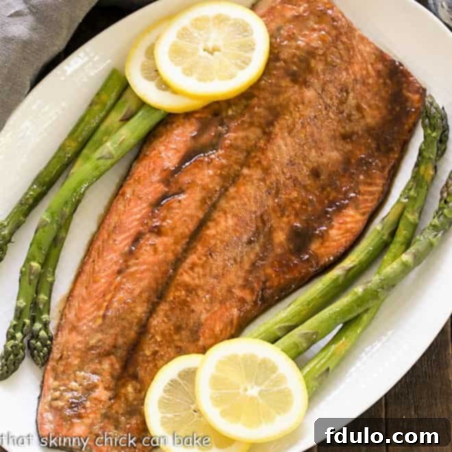 An overhead shot showcasing a beautifully prepared Easy Glazed Salmon on a pristine white platter, garnished with fresh herbs and lemon wedges, ready to be served.