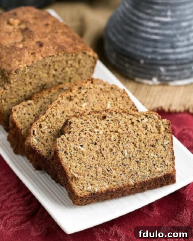 Easy Irish Brown Bread loaf and slices on a white tray, showcasing its rustic crust and dense texture.
