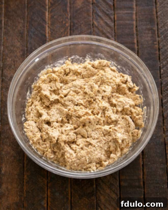 Buttermilk being stirred into the dry ingredients to form a soft dough.