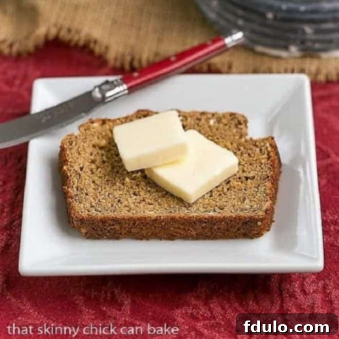 Easy Irish Brown Bread slice topped with a pat of butter on a square white plate, ready to be eaten.