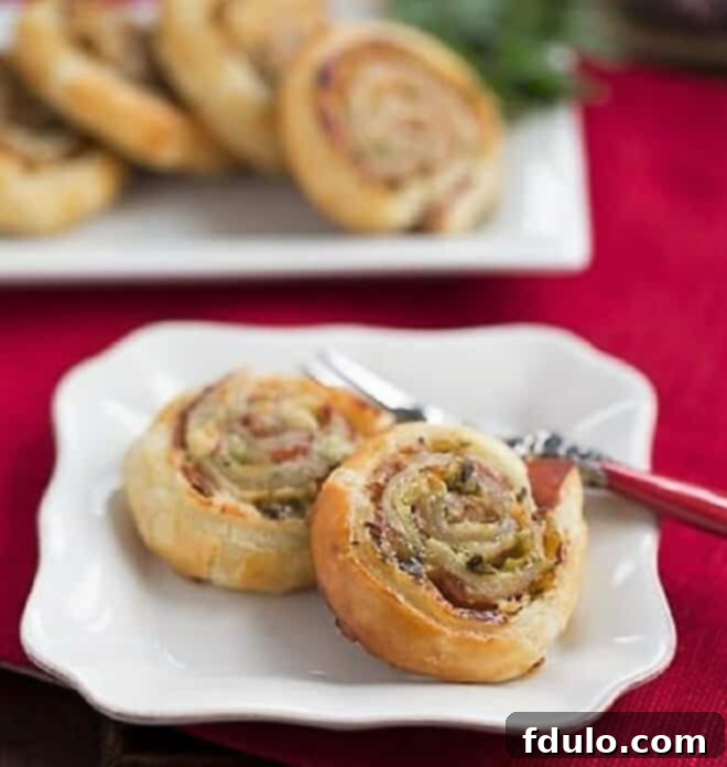 Savory Ham and Cheese Swirls 2 Prosciutto, Gruyere and Basil Pinwheels on a white plate with a fork, ready to be eaten