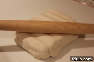 Rolling out homemade puff pastry for pinwheels First step of rolling out homemade puff pastry on a floured surface