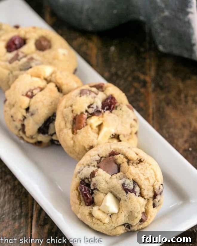 Chewy Cherry Chocolate Chunk Cookies displayed beautifully on a narrow white tray, highlighting their rich ingredients.