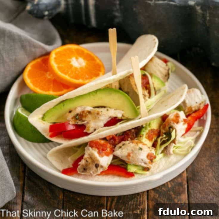 2 grilled fish tacos with slaw on a white plate