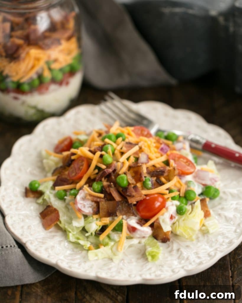 Make Ahead 7-Layer Salads in a Jar removed to a white salad plate