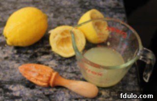 Fresh lemons and a reamer on a kitchen counter, ready for juicing for homemade ricotta