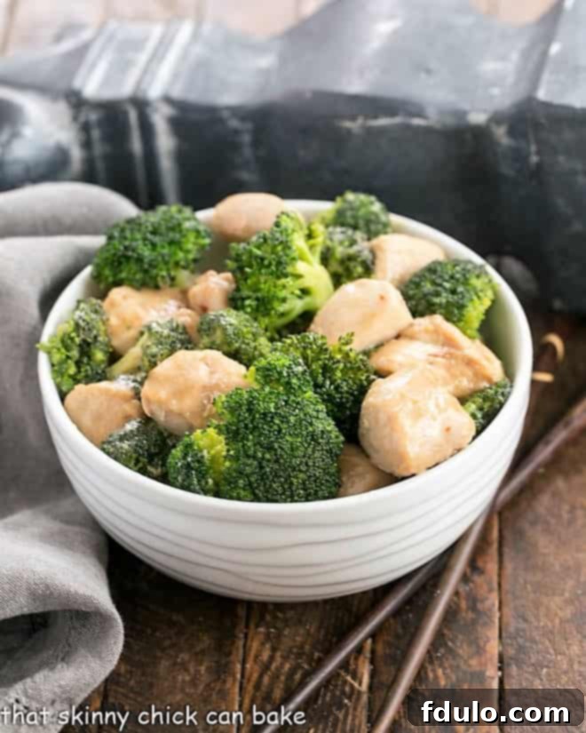 Close-up view of a vibrant Chicken and Broccoli Stir Fry in a white bowl, showcasing the tender chicken and bright green broccoli