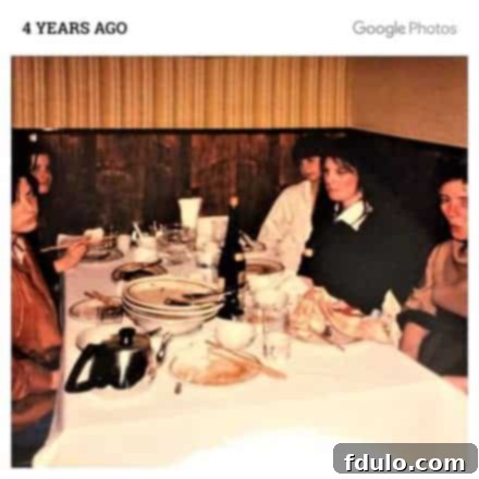 Vintage photo of a family sitting around a table in a Chinese restaurant, smiling.