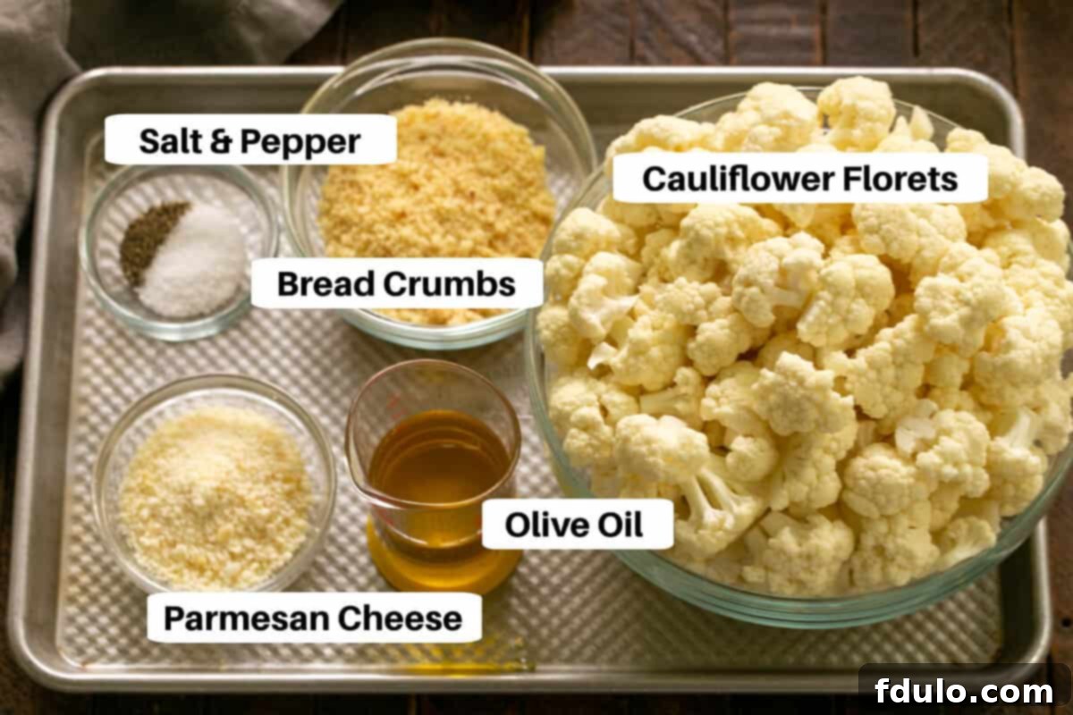 Overhead view of a sheet pan displaying all the fresh ingredients for roasted cauliflower, including florets, bread crumbs, Parmesan cheese, olive oil, salt, and pepper, neatly arranged and labeled.