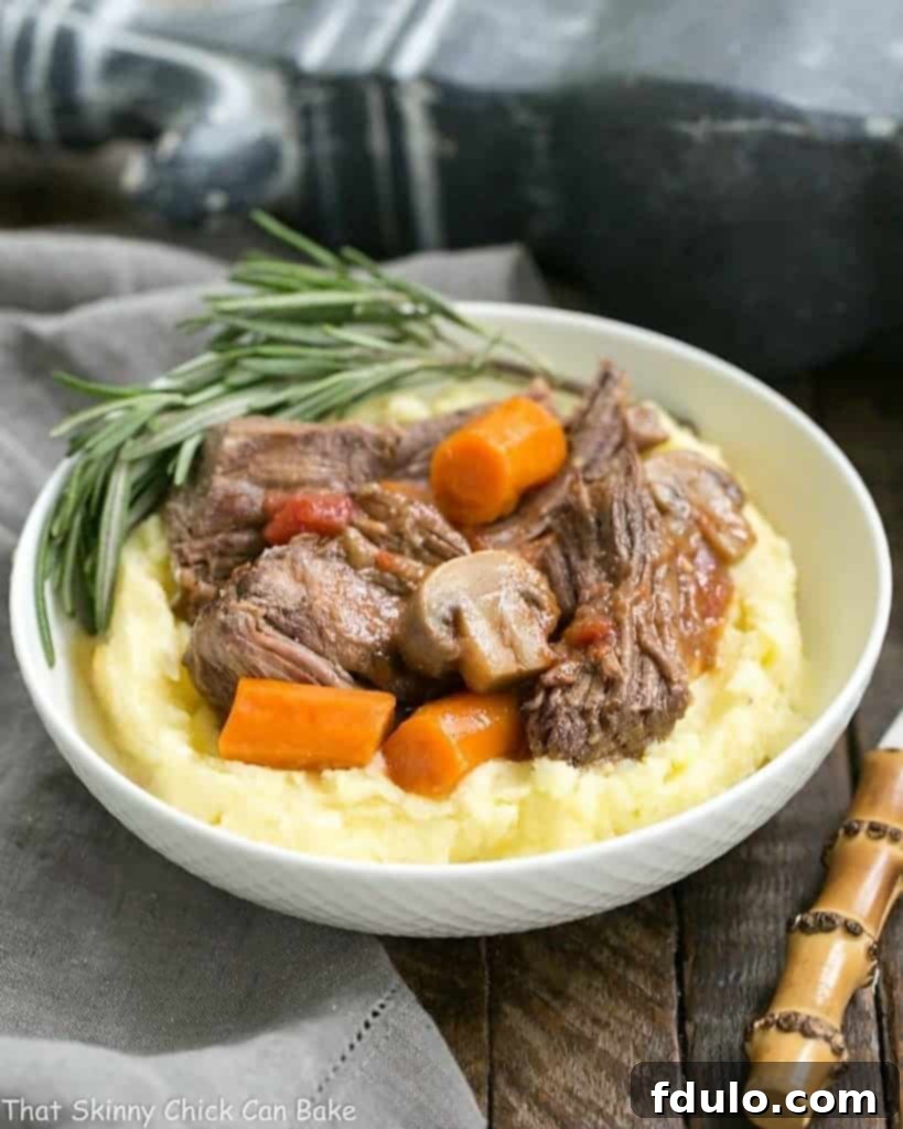 Oven Pot Roast - This is one unforgettable beef pot roast with an amazing depth of flavor! Pot Roast with Mushrooms, Tomatoes & Red Wine in a bowl with mashed potatoes.