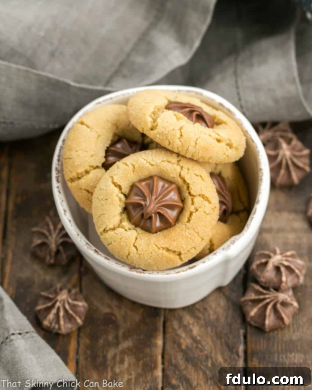 A small white bowl brimming with festive Star of Bethlehem Cookies, each adorned with a chocolate star.