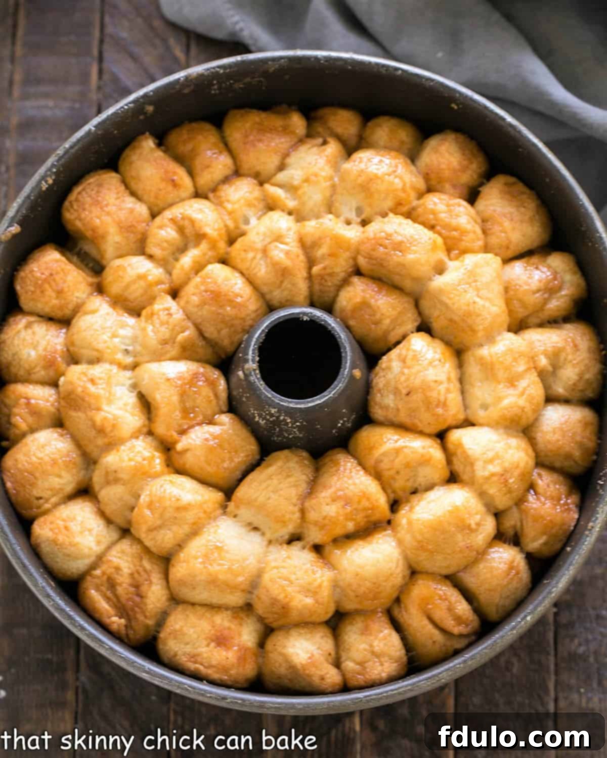 Effortless Monkey Bread Magic 3 A freshly baked golden brown bubble roll still in its dark metal tube pan, before being inverted onto a serving dish, showing its delicious caramelized crust.