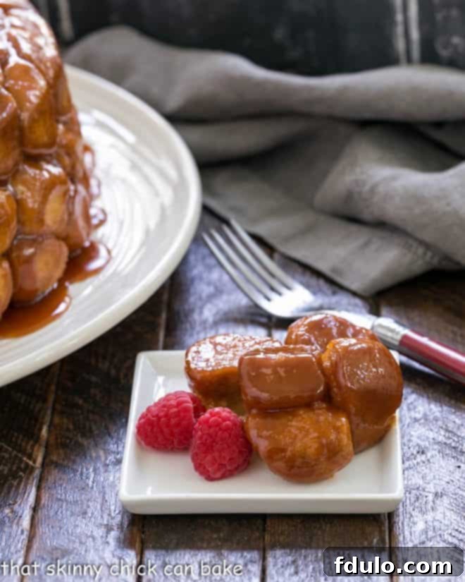 Effortless Monkey Bread Magic 4 A beautifully baked and inverted bubble bread on a square white plate, with two plump raspberries on top for garnish, showcasing its golden color and pull-apart texture.