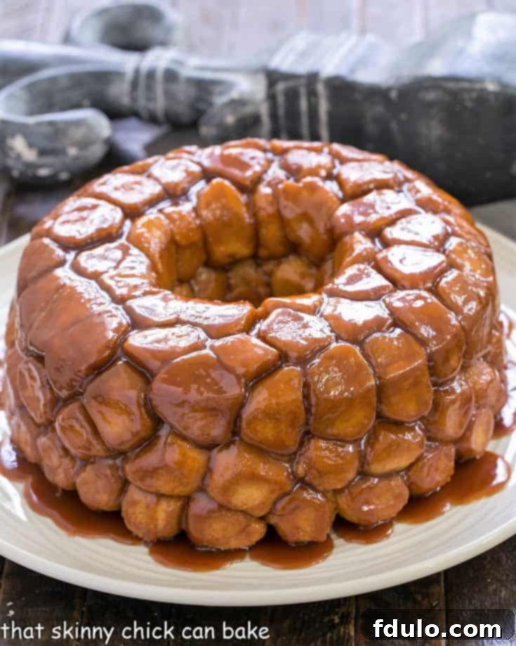 Effortless Monkey Bread Magic 5 A freshly baked golden brown bubble bread on a white serving dish, perfectly inverted and glistening with caramel glaze.