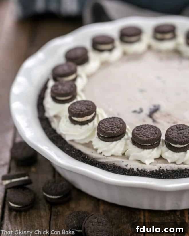 Layered Ice Cream Pie with Chocolate Cookie Crust in a white ceramic pie plate, ready to be served.