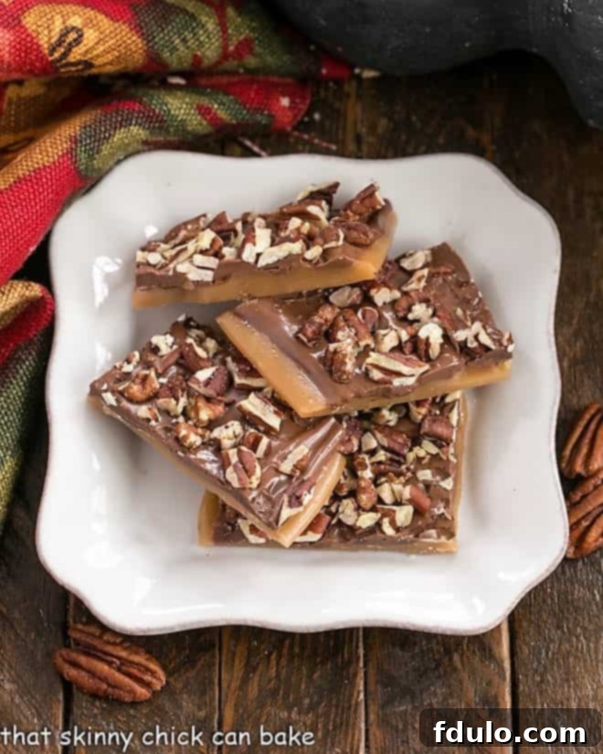 Overhead view of Classic English Toffee on a square white plate, with chocolate and pecan topping visible.
