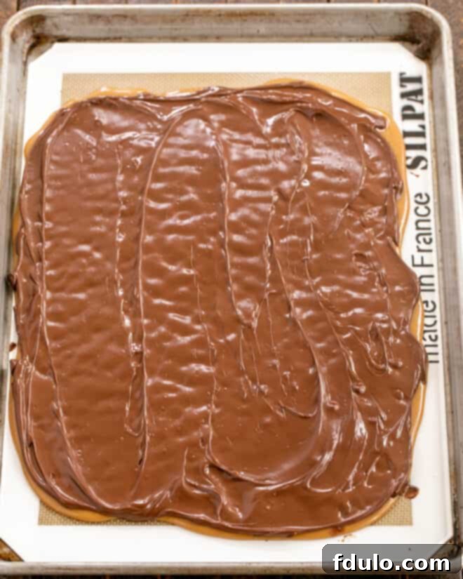 Step 2: Spreading melted chocolate evenly across the toffee base.