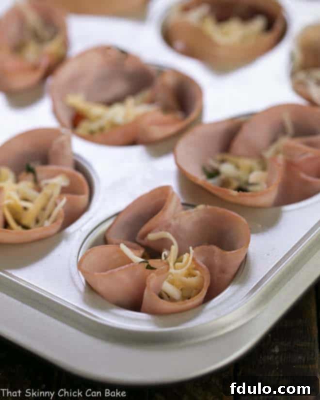 Egg Muffins in ham cups ready for the oven in a muffin tin.