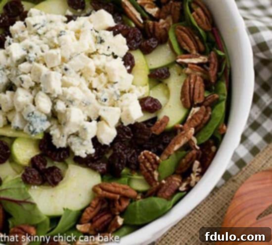 A beautifully presented Winter Salad with Apples, Pecans, Blue Cheese and Dried Cherries, ready to be served. This image captures the freshness and vibrant colors of the salad.
