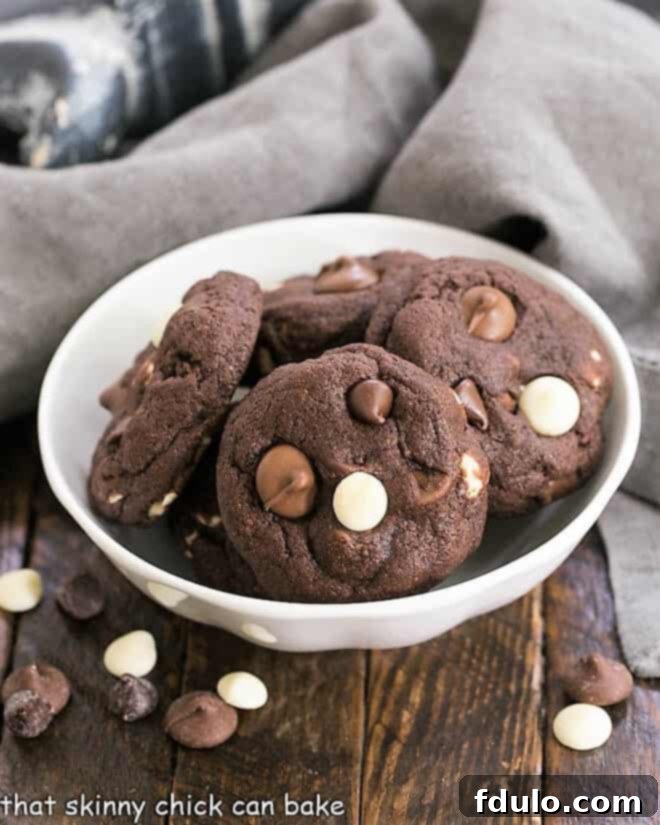 Decadent Four-Chocolate Cookies 9 Quadruple Chocolate Cookies in a white bowl surrounded by chocolate chips