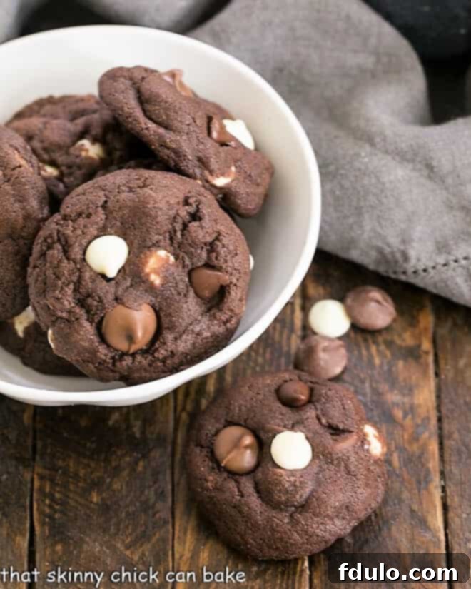 Chewy Quadruple Chocolate Cookies - outrageously delicious cocoa cookies for all the chocoholics in your life! Overhead with of a bowl of Quadruple Chocolate Cookies with one cookie removed.