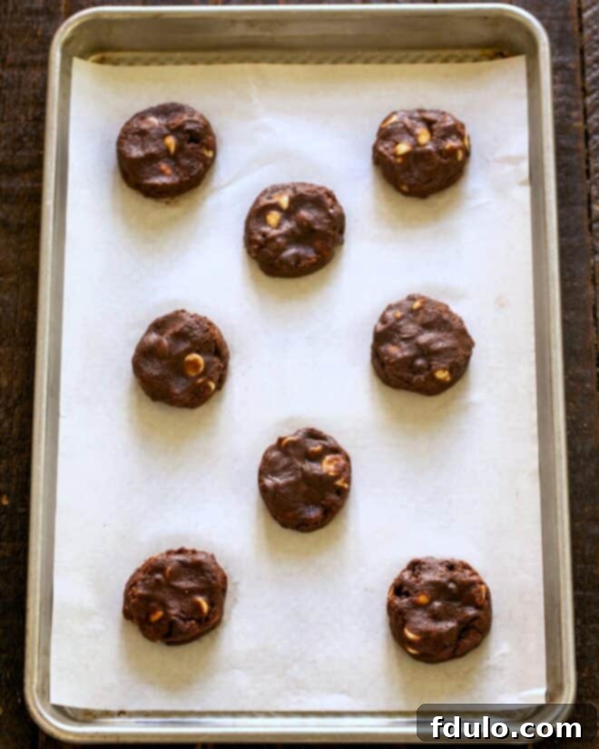 Decadent Four-Chocolate Cookies 7 Quadruple chocolate chip cookie dough balls on a baking sheet.