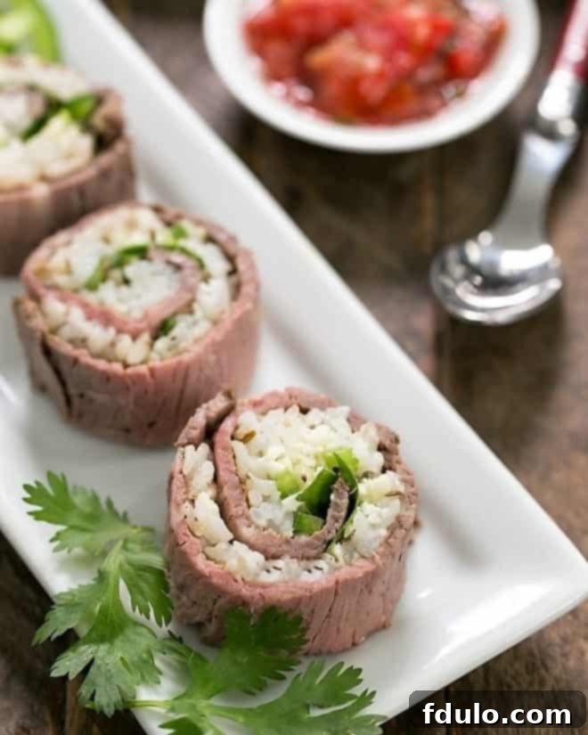 Beefshi - Beef Texan Rolls are a fun twist on classic sushi made with deli beef, sushi rice along with some Tex-Mex flavor boosters! Beefshi - Beef Texan Rolls on a narrow white tray, beautifully arranged for serving