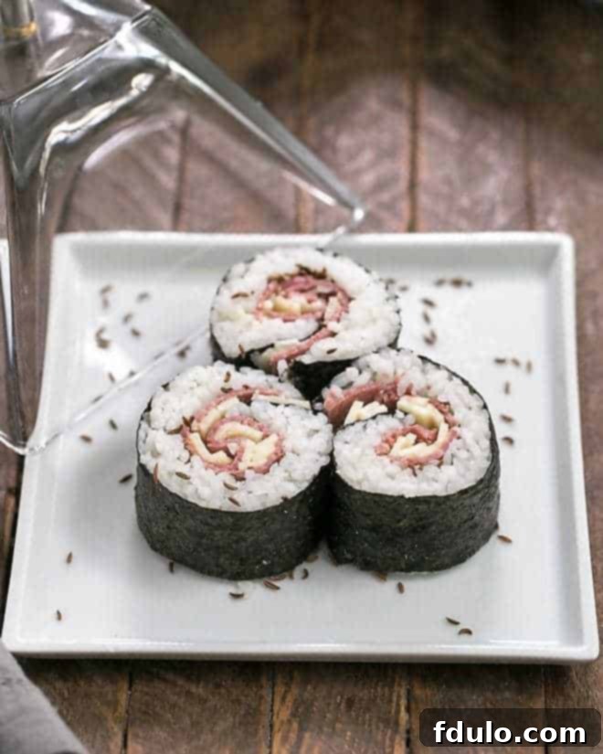 Beefshi - New York Deli Rolls are a fun twist on classic sushi made with deli pastrami, sushi rice and Swiss Cheese Beefshi - New York Deli Rolls on a square white plate, artfully presented