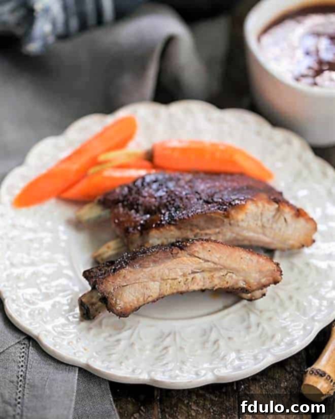 Instant Pot Baby Back Ribs on a white plate with carrots