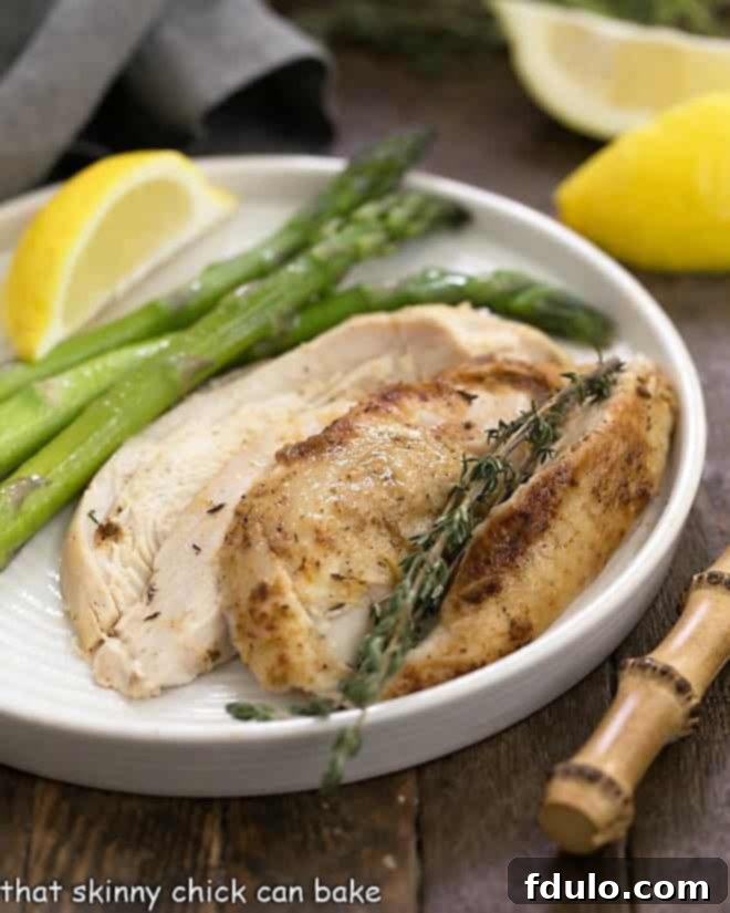 Instant Pot Rotisserie Chicken sliced with steamed asparagus on a white dinner plate, ready to serve.