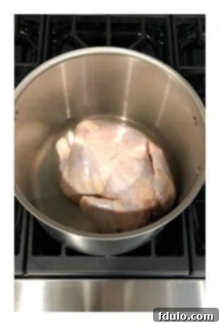 Place a whole chicken in a large stockpot for making soup.
