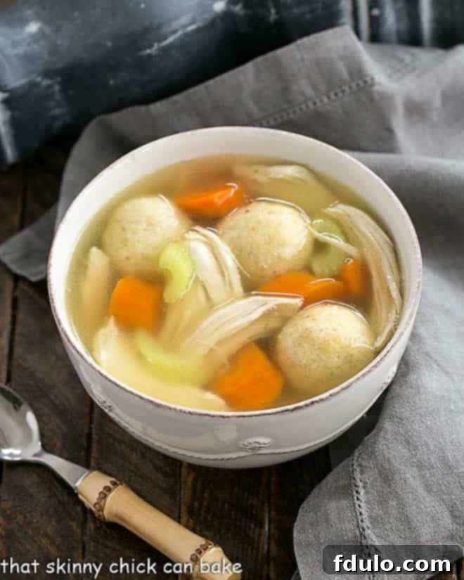 Homemade Chicken Vegetable Soup in a white bowl with a bamboo spoon