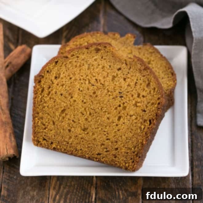 A slice of classic pumpkin bread, showcasing its moist texture and golden-brown crust.